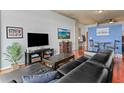 Living room boasts a stylish entertainment center, black leather sofa, and open layout leading to a dining area at 250 Pharr Ne Rd # 1914, Atlanta, GA 30305
