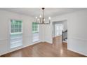 Bright dining room with hardwood floors, white trim, and a modern chandelier, illuminated by natural light through large windows at 4536 Mountain Creek Ne Dr, Roswell, GA 30075