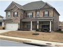 Charming two-story brick home featuring a covered porch with swing and attached garage at 3566 Andover Way, Buford, GA 30519