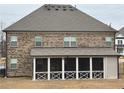 Spacious backyard view of a home featuring a screened-in porch and brick exterior at 3566 Andover Way, Buford, GA 30519