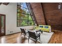 Bright living room with vaulted wood ceilings, hardwood floors, and a wall of windows offering stunning outdoor views at 3567 Beachhill Dr, Atlanta, GA 30340