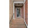 Welcoming front porch with brick steps, black hand railing, and an open door that reveals the interior stairs at 690 Cobblestone Creek Ln, Mableton, GA 30126
