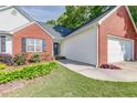 Close up of the exterior of the home featuring brick accents and a manicured front yard at 1720 Alcovy River Dr, Dacula, GA 30019
