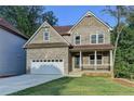 Charming two-story brick home featuring a covered front porch and attached two-car garage at 194 Jennifer Nw Ln, Lilburn, GA 30047