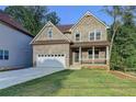 Charming two-story brick home featuring a covered front porch and attached two-car garage at 194 Jennifer Nw Ln, Lilburn, GA 30047