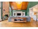 Open-concept living room with vaulted wood ceilings, hardwood floors, stone fireplace and ample seating at 2855 Drayton Hall Dr, Buford, GA 30519
