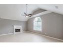 Spacious living room featuring vaulted ceilings, a cozy fireplace, and large arched window at 3022 Stonebridge Creek Dr, Lithonia, GA 30058