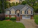Charming two-story home featuring a brick and stucco facade, black shutters, and a well-manicured lawn at 47 Centerport Dr, White, GA 30184