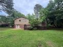 Exterior view of the home featuring a wooden deck, lawn, and lush trees, showcasing the backyard and outdoor space at 4135 Moore Rd, Conley, GA 30288