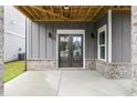 Covered entryway features double doors, gray siding, and brick foundation at 1419 Coretta Bnd, Atlanta, GA 30318