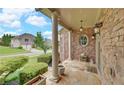 Charming porch with stone details, elegant lighting, and landscaping, perfect for enjoying the outdoors at 3020 Crooked Stick Dr, Cumming, GA 30041