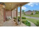 Inviting front porch with stone flooring, decorative pillars, and cozy seating, ideal for relaxing at 3020 Crooked Stick Dr, Cumming, GA 30041