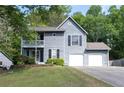Two-story home featuring a two-car garage, second story balcony, and a well-maintained front lawn with shrubs at 4971 Sharp Way, Duluth, GA 30096