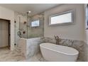 A luxurious bathroom featuring a freestanding tub, glass enclosed shower, and elegant marble tile at 11305 Knollwood Bend, Johns Creek, GA 30097