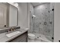 An elegant bathroom featuring marble tiling, a glass enclosed shower, and a modern vanity sink at 11305 Knollwood Bend, Johns Creek, GA 30097