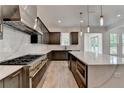 A modern kitchen with stainless steel appliances, gas range, a large island, and beautiful pendant lights at 11305 Knollwood Bend, Johns Creek, GA 30097