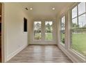 Bright sunroom with hardwood flooring and many large windows overlooking a beautiful backyard at 11305 Knollwood Bend, Johns Creek, GA 30097