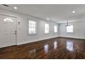 Spacious living room with hardwood floors, neutral walls, many windows, and modern lighting at 2195 Penelope Nw St, Atlanta, GA 30314