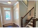 Inviting foyer showcasing staircase with wooden banister, tile floor, and natural light from the door's window at 7165 Winthrop Rd, Alpharetta, GA 30005