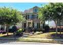 Inviting two-story home features manicured landscaping, complemented by mature trees and a well-maintained lawn at 7165 Winthrop Rd, Alpharetta, GA 30005