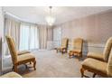 Formal living room with plush carpet, decorative chandelier, and ample seating creating a cozy ambiance at 1366 Maple Ridge Dr, Suwanee, GA 30024