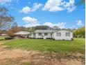 Charming single-story home with a covered porch, white siding, and a spacious front yard at 1871 Weems Rd, Locust Grove, GA 30248