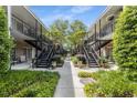 Exterior view of a building complex with black metal staircases, lush greenery, and a paved walkway at 3675 Peachtree Ne Rd # 9, Atlanta, GA 30319