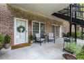 Cozy outdoor patio featuring chairs, table, wreath on door, and landscaped surroundings at 3675 Peachtree Ne Rd # 9, Atlanta, GA 30319