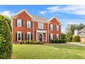Elegant brick home with black shutters, a well-kept lawn, and mature trees at 3720 Bridle Ridge Dr, Suwanee, GA 30024