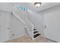 Bright entryway featuring a white staircase, tile flooring, and contemporary lighting fixtures at 1668 Terrell Ridge Se Dr, Marietta, GA 30067