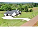 An aerial view captures this farmhouse-style home on an expansive lot, and a long driveway at 300 Eminence Peak, Rydal, GA 30171