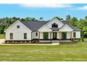 Charming modern farmhouse with large front yard, wooden columns, and black trim windows at 300 Eminence Peak, Rydal, GA 30171