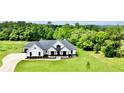 A beautiful new construction home is framed by mature trees and a lush green lawn at 300 Eminence Peak, Rydal, GA 30171