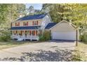 Two-story home featuring red shutters, a white porch, and a driveway with a basketball hoop at 4092 Deerbrook Sw Way, Lilburn, GA 30047