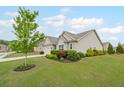 Charming home featuring a well-manicured lawn, an inviting entryway, and a beautiful tree at 5775 Stellata Cir, Cumming, GA 30028