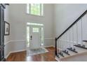 Bright foyer features a staircase, hardwood floors, and natural light from the front door at 630 Silverberry Ln, Sugar Hill, GA 30518