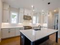 Modern kitchen features white cabinets, stainless steel appliances, and large island with pendant lighting at 1415 Coretta Bnd, Atlanta, GA 30318