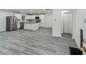 Modern kitchen with white cabinets, stainless steel appliances, an island, and wood plank flooring at 1482 Connally Sw Ave, Atlanta, GA 30310