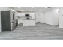 Open kitchen with white cabinets, stainless steel appliances, granite countertops, and wood plank flooring at 1482 Connally Sw Ave, Atlanta, GA 30310