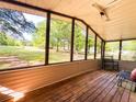 Relaxing screened porch with wood floors and views of the expansive lawn and mature trees, perfect for outdoor living at 148 Boogers Hill Rd, Oxford, GA 30054