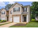 Charming townhome featuring a brick facade, black shutters, and an attached garage at 3565 Brycewood Dr, Decatur, GA 30034