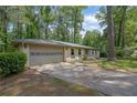Ranch-style brick home featuring a two-car garage and mature landscaping at 4420 Lake Breeze Dr, Stone Mountain, GA 30083