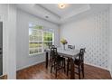Bright dining room with large window, wood floors, and stylish wallpaper at 6045 Park Close, Fairburn, GA 30213