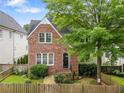 Charming two-story brick home with a mature tree and a well-manicured front yard with a wooden fence at 2685 Grady Se St, Smyrna, GA 30080