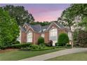 Stunning brick home featuring manicured landscaping, a gabled roof, and prominent arched windows at 452 Brushstroke Se Ct, Marietta, GA 30067