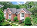 Elegant brick home showcasing mature trees, lush landscaping, and architectural details at 452 Brushstroke Se Ct, Marietta, GA 30067