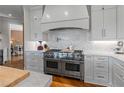 Gourmet kitchen with stainless steel appliances, a herringbone backsplash, and marble countertops at 6515 Ashbourne Ct, Suwanee, GA 30024