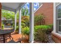 Inviting brick-paved front porch with white pillars and seating and view of the yard and front of the home at 8730 Parker Pl, Roswell, GA 30076