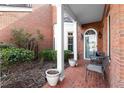 Charming covered front porch with brick flooring, creating a cozy outdoor seating area at 8730 Parker Pl, Roswell, GA 30076