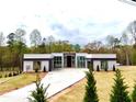 Modern home with long driveway, green lawn, and minimalist landscaping, showcasing clean lines at 0 Highway 279, Fayetteville, GA 30214